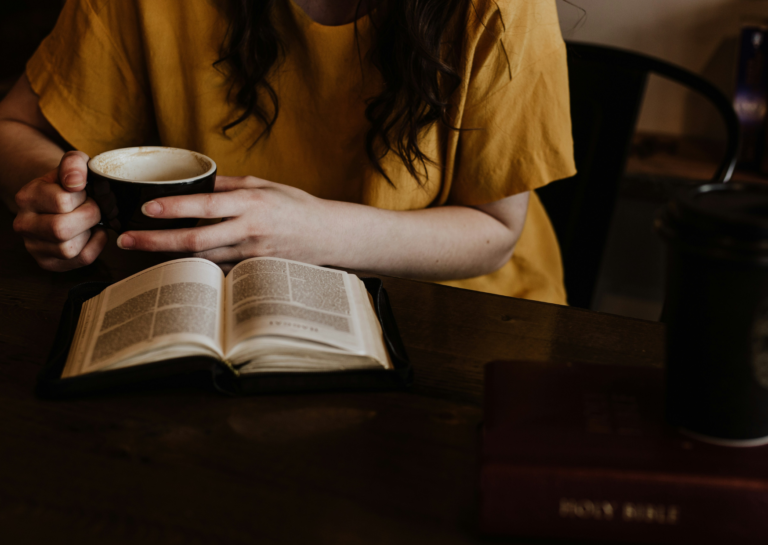 Woman sitting alone with book and mug